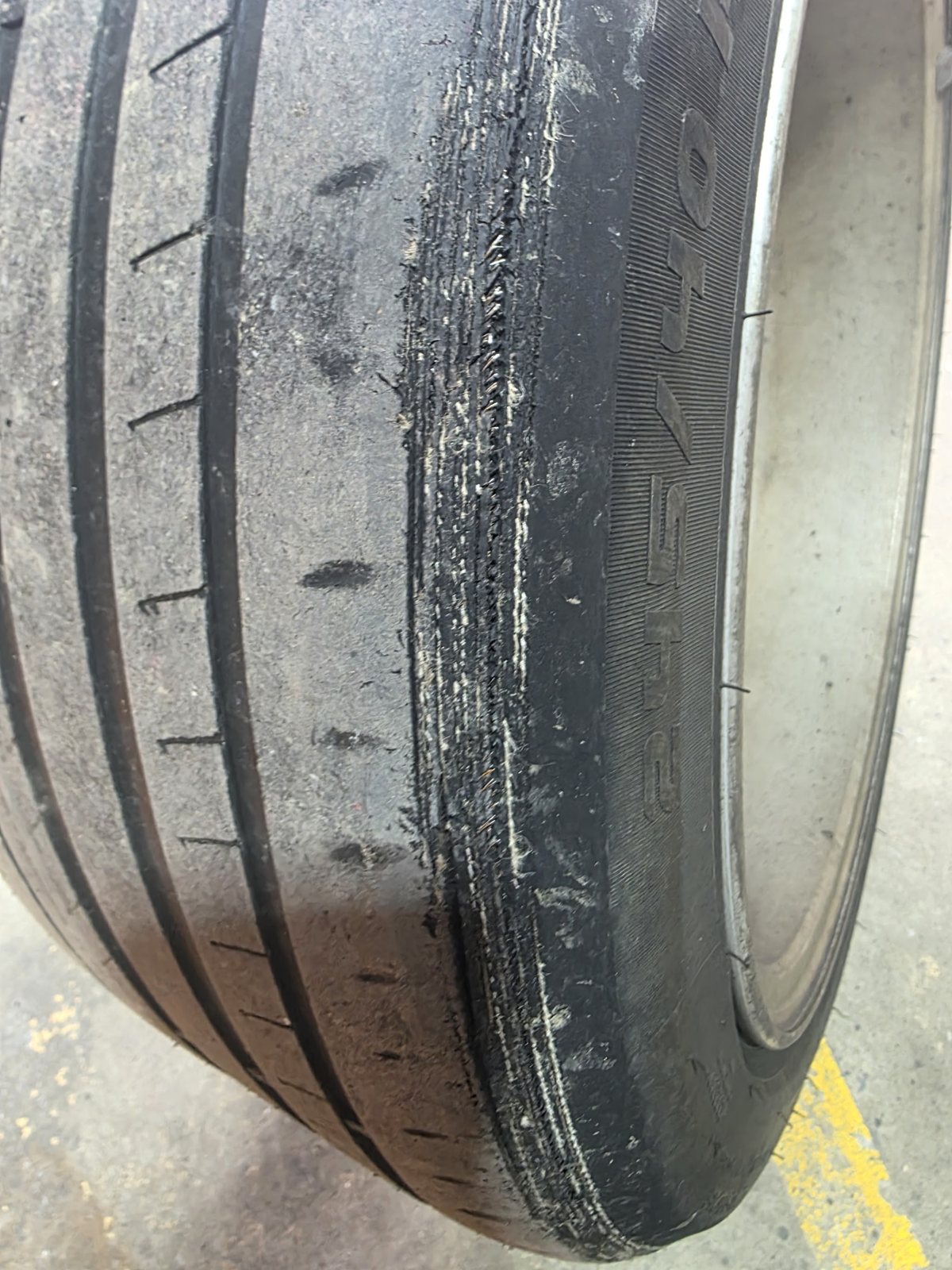 Close up of a car tyre worn through on the shoulder, cords showing