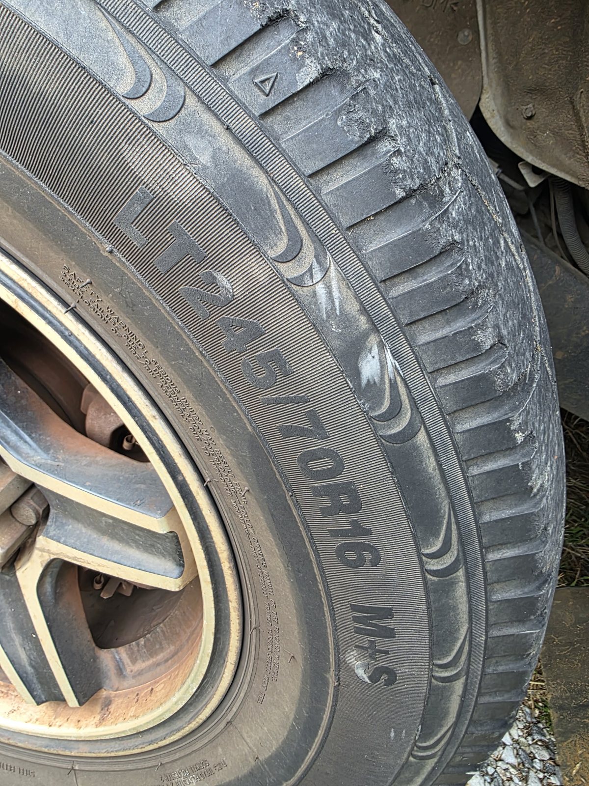 Close up of a light truck tyre with ragged, worn tread blocks